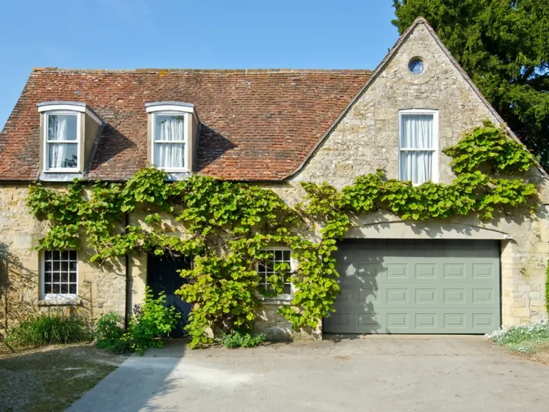 Green sectional garage door on a stone house